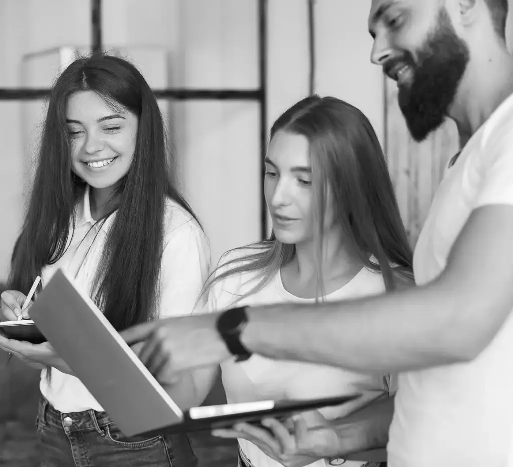 Rahat bir ofis toplantısında dizüstü bilgisayar ve tabletle birlikte çalışan genç yaratıcı ekip.